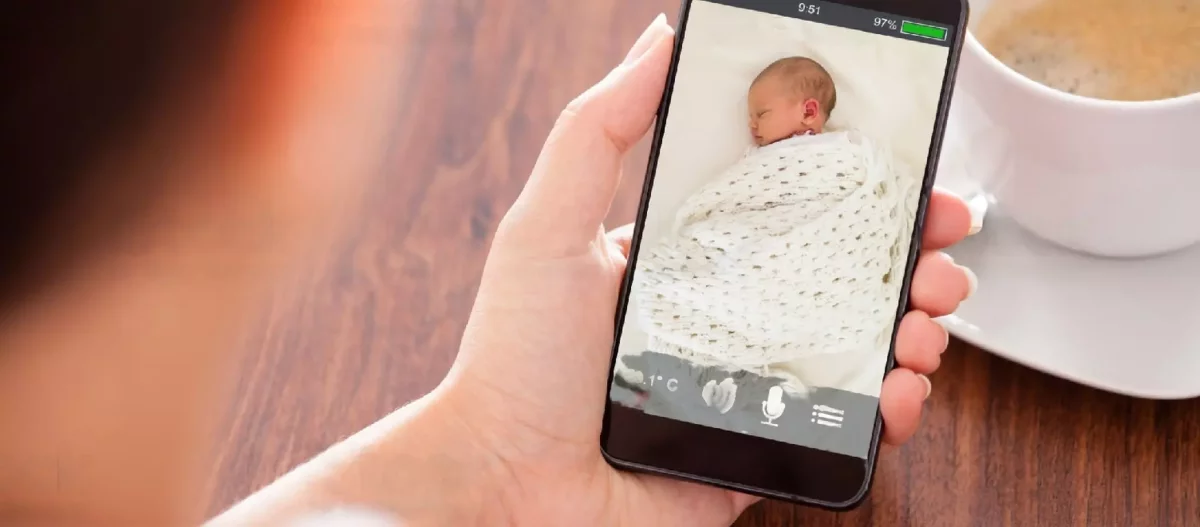 Parent qui surveille son bébé sur son smartphone